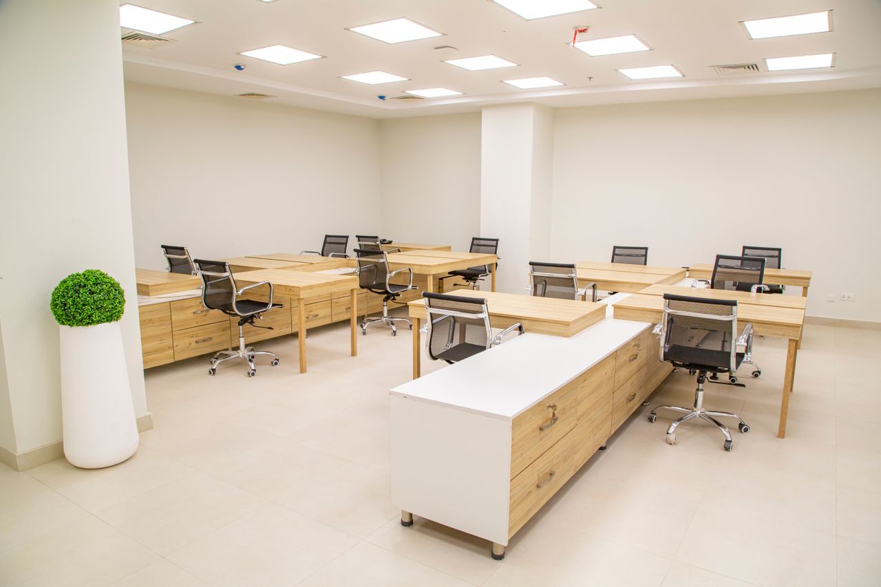 The Art of Drawing Readers In: Your attractive post title goes here A bright, modern office space featuring wooden desks, rolling chairs, and ample lighting.
