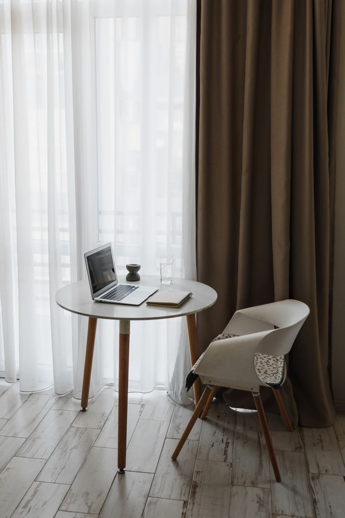 Learn Jackbit Game Mechanics Safely Through Demo Practice A stylish and minimalist home office setup featuring a table, chair, and laptop by large windows.