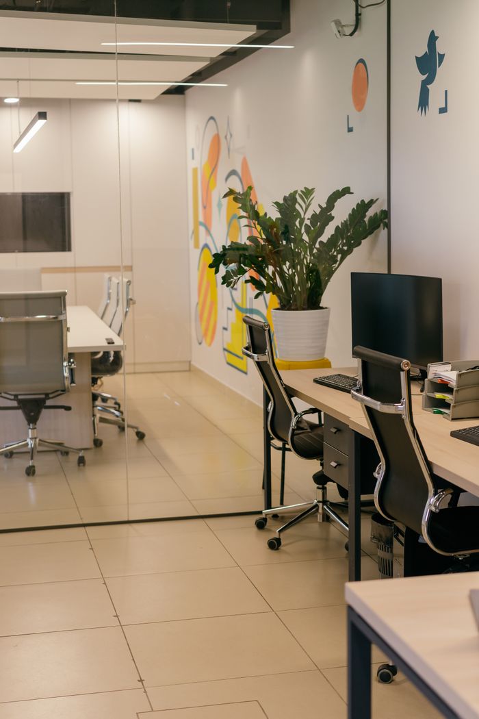 services-01 Spacious and contemporary office interior with glass partitions, stylish furniture, and vibrant wall art.